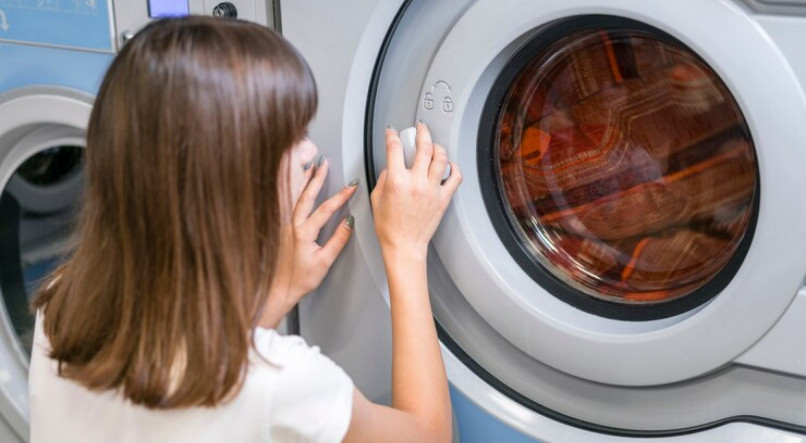 Imagem ilustrativa de mulher colocando blackout para lavar na máquina