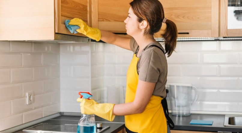 Imagem ilustrativa de mulher usando mistura caseira para limpar cozinha
