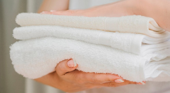 Imagem ilustrativa de pessoa segurando toalhas macias e cheirosas