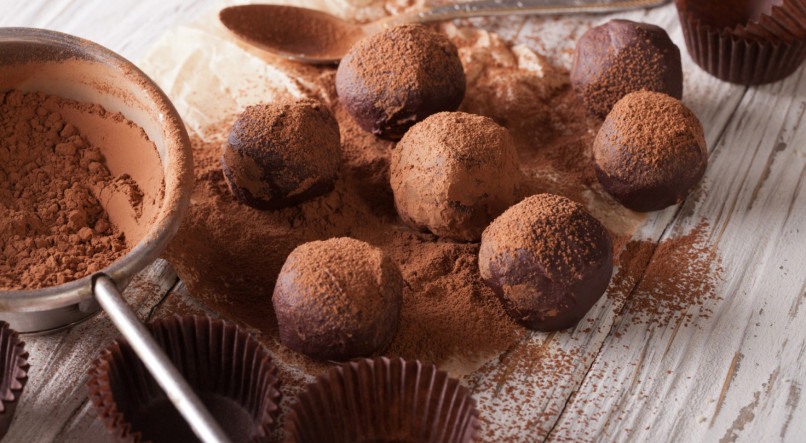 chocolate truffles sprinkled with cocoa powder close-up on the table. horizontal

