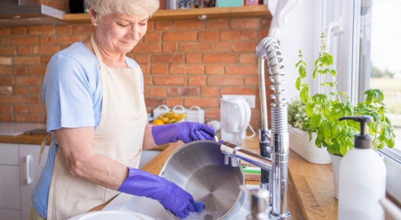 Imagem ilustrativa de uma pessoa lavando louça 