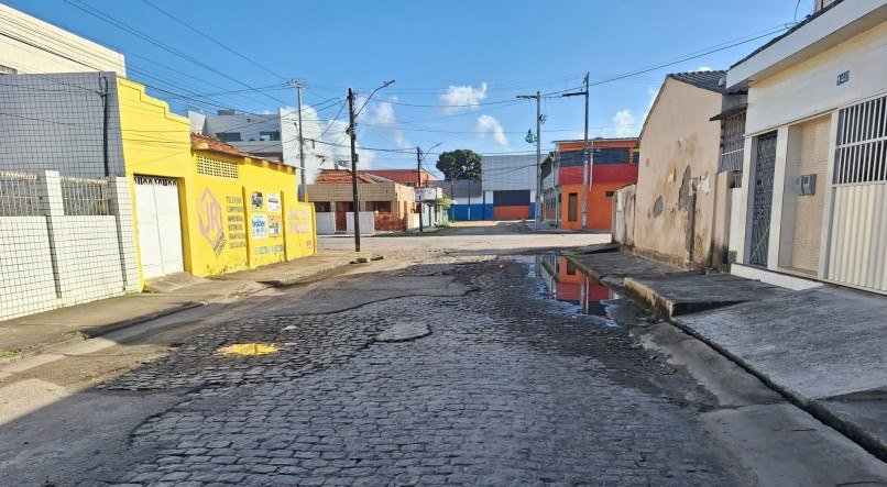 Rua sem rede de drenagem de água pluvial e com calçamento deteriorado