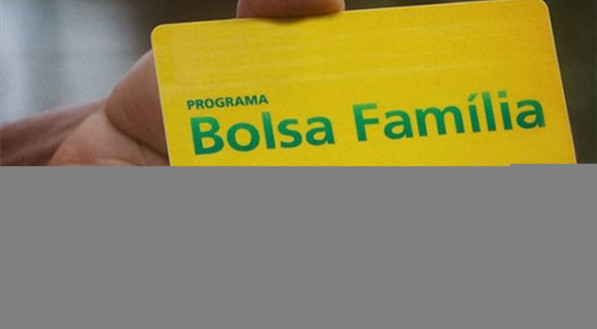 Imagem ilustra uma mão segurando o cartão do Bolsa Famílias; beneficiários podem sacar valor com o cartão do programa