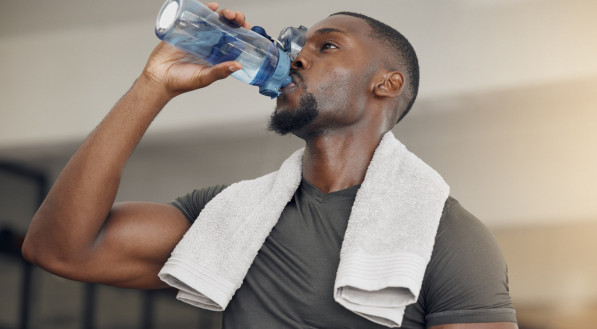 Homem bebendo água durante treino