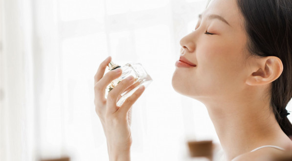 Imagem ilustrativa de uma mulher cheirando perfume