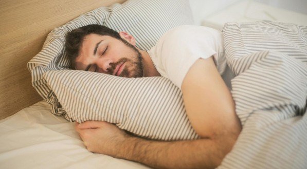 Homem dormindo na cama 