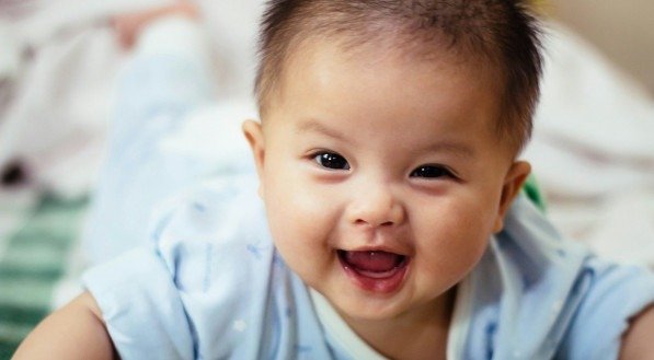 Na imagem, um bebê recém-nascido sorrindo