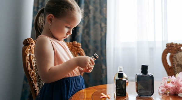 Imagem ilustrativa de criança passando perfume
