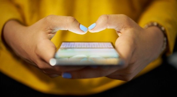 Mulher digitando mensagem de telefone na rede social à noite