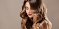 Jovem, linda mulher de cabelos castanhos com cabelos longos densos e tingidos. Arte de cabeleireiro e coloração de cabelo.