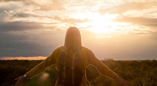 mulher vendo o por do sol