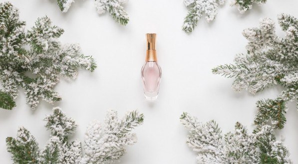 Christmas still life. Spruce branches form a frame with perfume bottle in the middle.