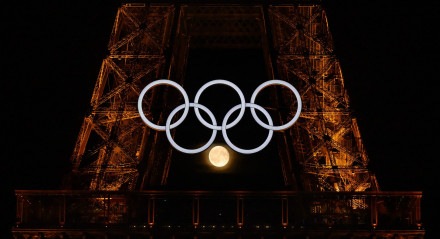 Imagem da Lua em meio aos anéis olímpicos da Torre Eiffel