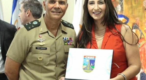 Natalia Ribeiro, apresentadora da Rádio Jornal recebe do general Maurílio Ribeiro o diploma de Amiga do Comando Militar do Nordeste