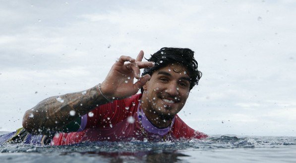 Imagem de Gabriel Medina fazendo o gesto de número 1 dentro do mar do Taiti