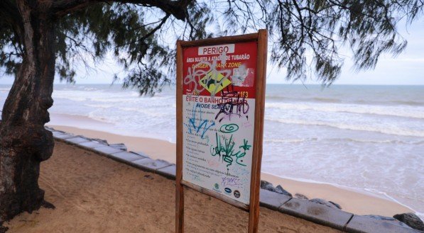 Foto mostra pichação em placa de alerta de ataques de tubarão, em orla de Boa Viagem, no Grande Recife 