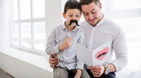 Imagem ilustrativa de pai lendo cartão de mensagem do filho no Dia dos Pais