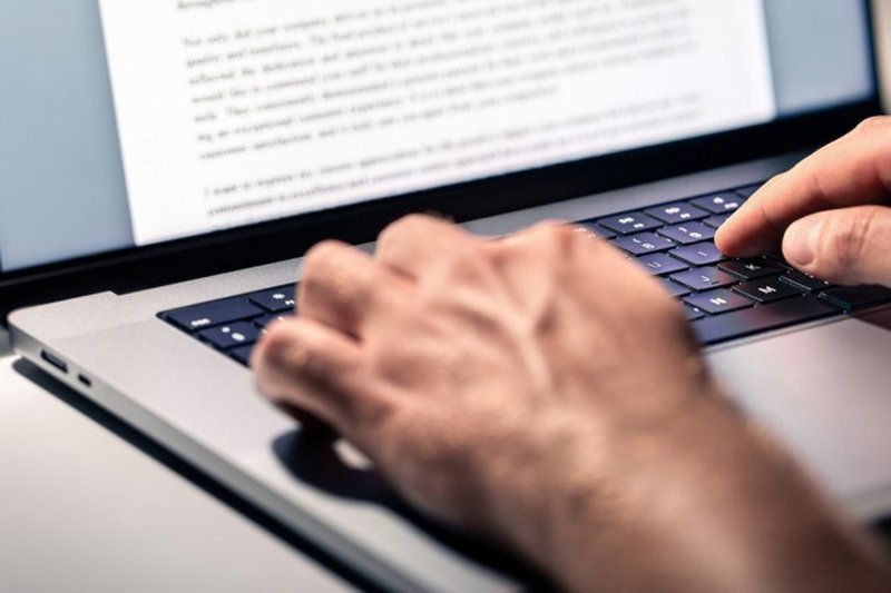 Imagem de mãos digitando em um computador