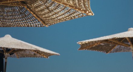 Imagem ilustrativa de guarda-sóis na praia