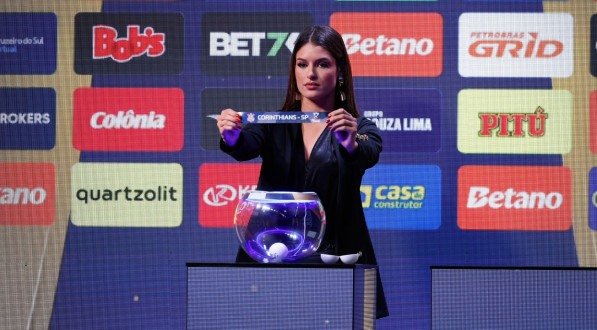 Mulher segura papel com o nome Corinthians no sorteio da Copa do Brasil