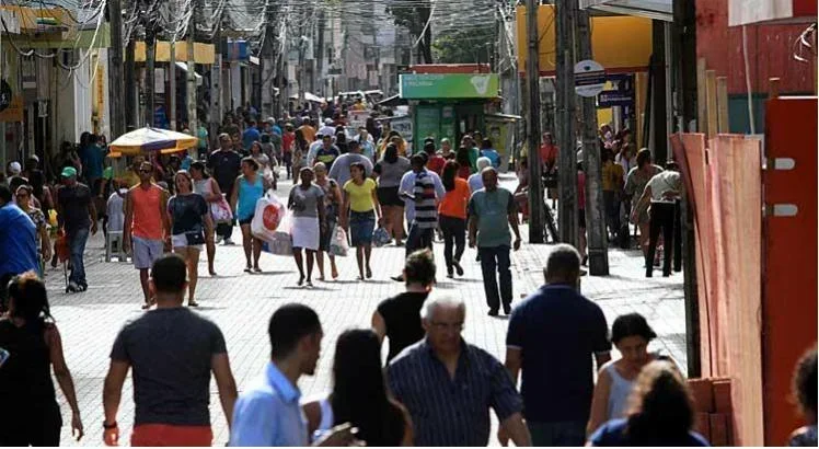 Várias pessoas andando pelo centro do Recife. 