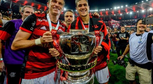 Pedro e Felipe Luís com o troféu da Copa do Brasil