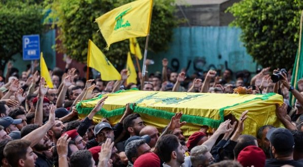 Integrantes do Hezbollah carregam cachões de mortos em ação atribuída ao Mossad, inteligência de Israel