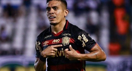 Igor Carius segurando a camisa do Sport e apontando para o escudo do clube Rubro-Negro