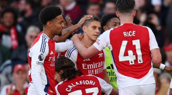 Trossard sendo abraçados por outros jogadores do Arsenal