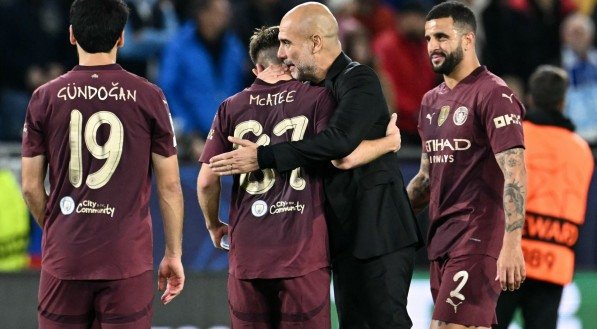 Imagem dos jogadores do Manchester City comemorando a vitória na 2ª rodada da Champions League com o técnico Guardiola