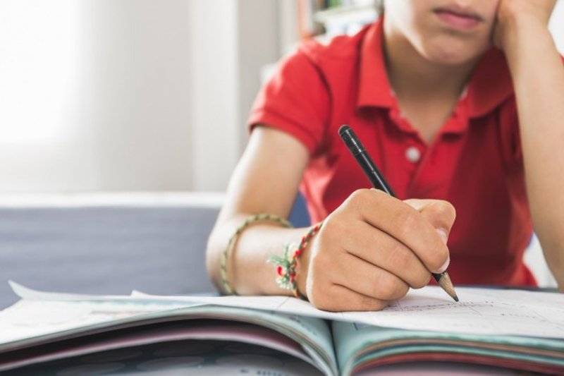 Imagem ilustrativa: criança estudando com dificuldade devido à dislexia.