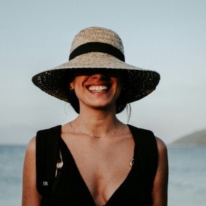 Imagem ilustrativa de uma mulher sorrindo, enquanto viaja para a praia