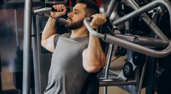 Homem durante prática de exercício em academia