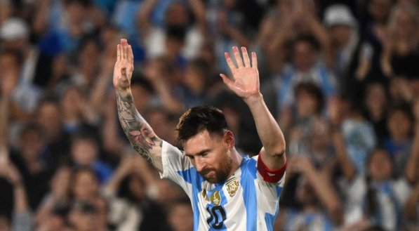 Lionel Messi com os braços erguidos agradece saudações da torcida