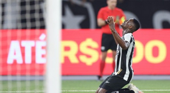 Luiz Henrique, atacante do Botafogo, ajoelhado e com as mãos erguidas