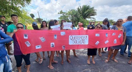 Imagem de moradores segurando cartazes durante protesto em Igarassu