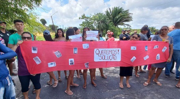 Imagem de moradores segurando cartazes durante protesto em Igarassu