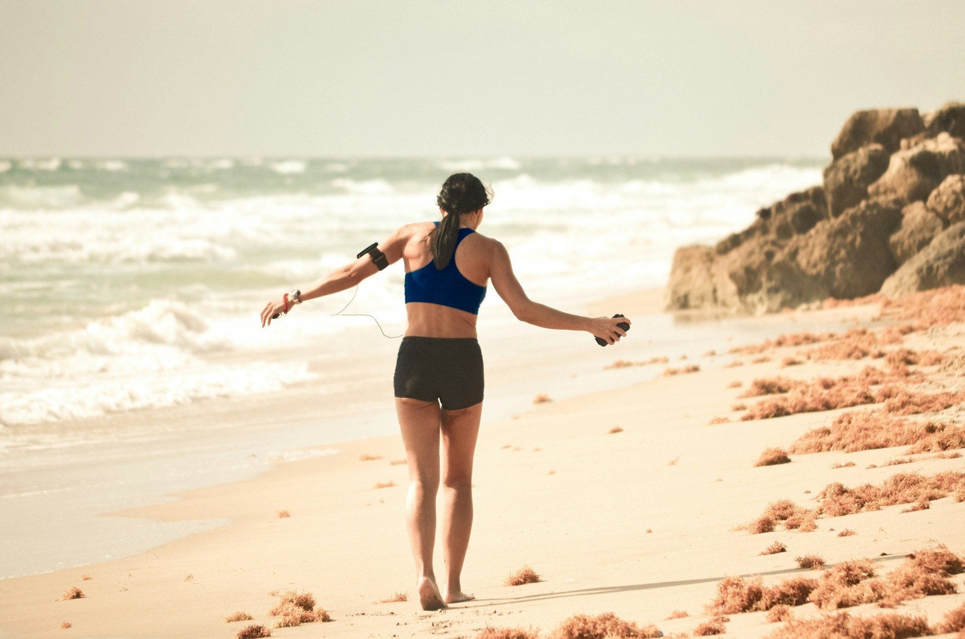 Imagem ilustrativa de uma mulher caminhando feliz na praia