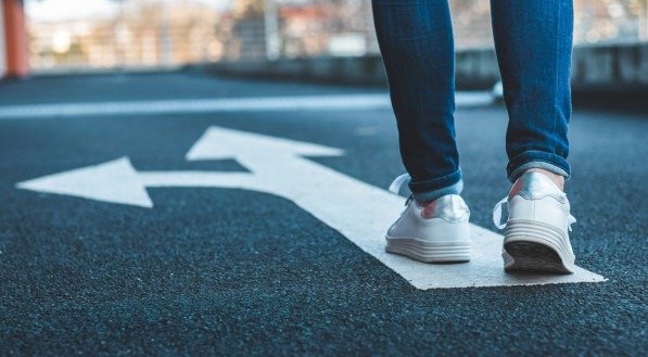 Tomar decisões que caminho a percorrer. Passeio no sinal direcional na estrada asfaltada