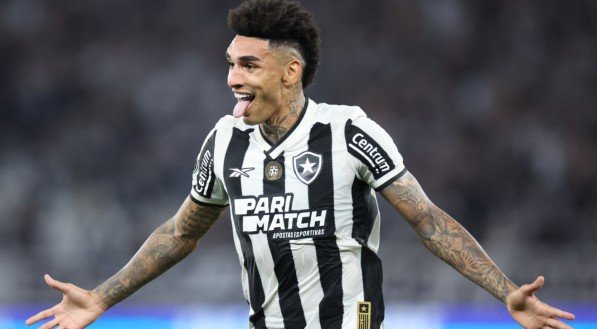 Igor Jesus, atacante do Botafogo, com os braços abertos ao celebrar gol