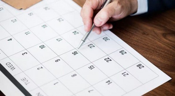 Imagem de uma caneta apontando para o número 16 em um calendário