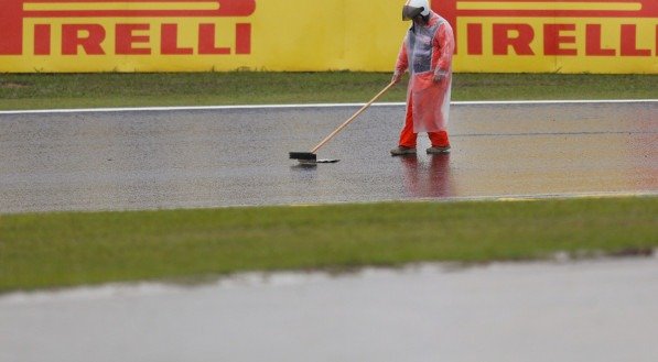 Homem com a vassoura limpa a pista de Interlagos