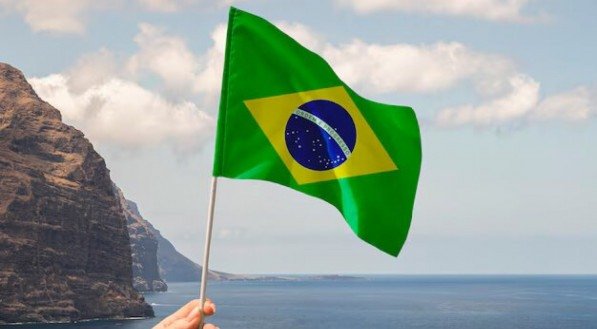 Imagem da bandeira do Brasil em frente ao horizonte