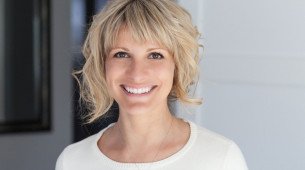 Imagem de mulher madura loira com cabelos curtos sorrindo.