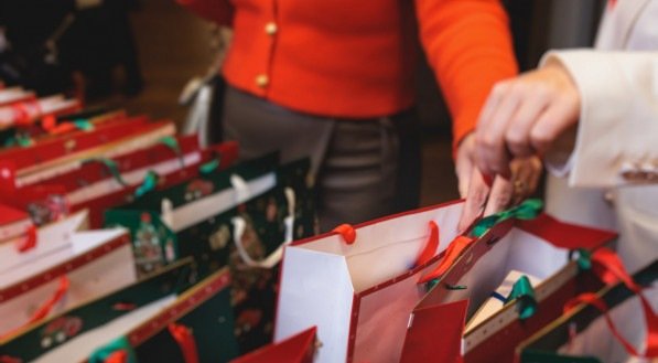 Sacos de papel verde e branco vermelhos, troca de presentes com colegas, representando lembranças de amigo secreto.