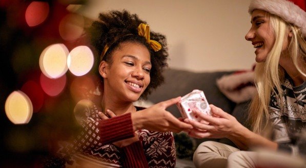 Imagem de duas mulheres trocando presentes de Natal e Ano novo