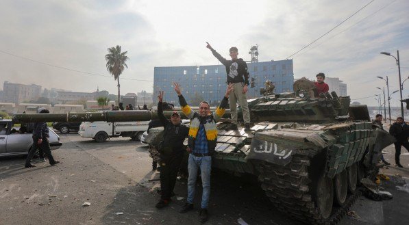 As pessoas comemoram na Praça Umayyad, em Damasco a queda do governo Assad