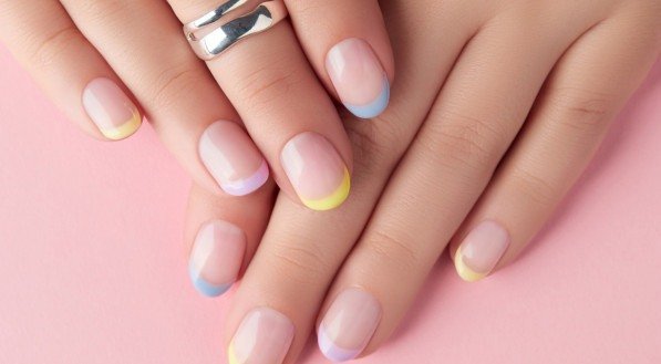 Unhas com francesinha colorida.