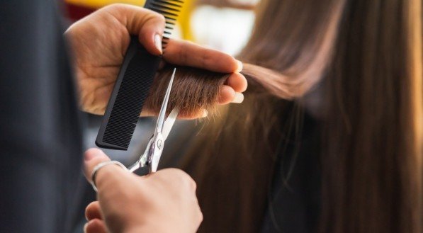 Imagem ilustrativa de uma mulher cortando o cabelo