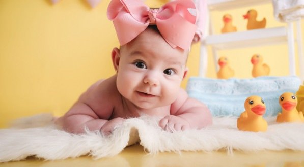 Imagem de bebê fazendo pose enquanto toma banho.